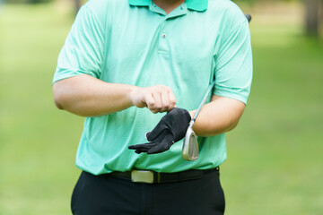 Male golfer is wearing a glove.