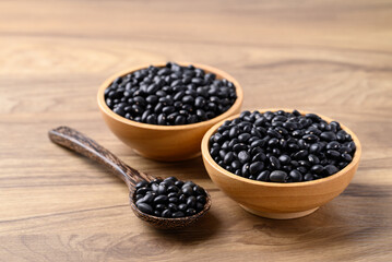 Black bean in bowl with spoon on wooden background, Food ingredient