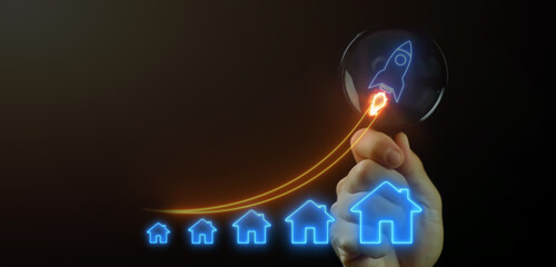 Finance and banking about development, investment ideas about real estate companies, financial success and growth concept. Businessman pointing rocket spaceship with house icons on virtual screen.