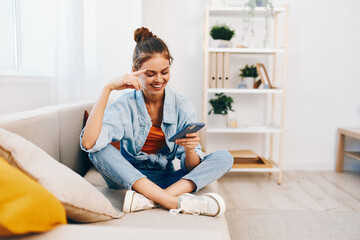 Obraz premium Sofa woman holding phone at home, couch mobile smile online.