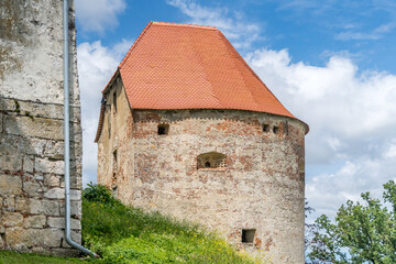Obraz premium Round cannon gun tower with loopholes, red roof in Ptuj castle Slovenia