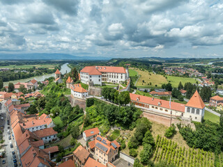 Aerial view of Ptuj castle with red roof gothic renaissance palace building, bastions, towers on a hilltop above the old town, Drava river in Slovenia