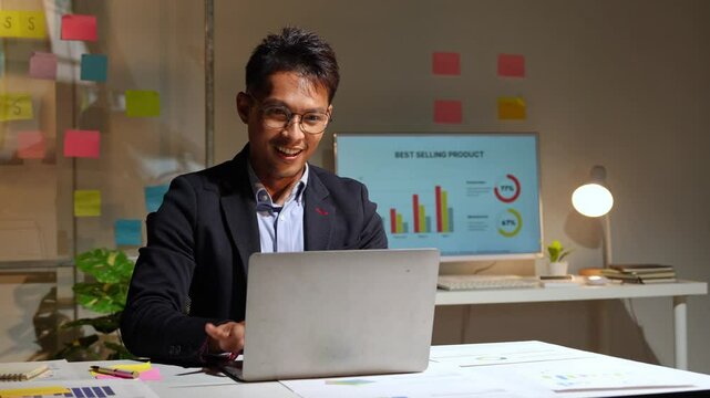 Businessman happily recording data on laptop, PC, comparing details from graphs. Business income charts in real estate, taxes, management, marketing, successful office technology.