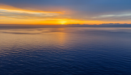 Obraz premium Tranquil Ocean Sunset with Golden and Blue Hues