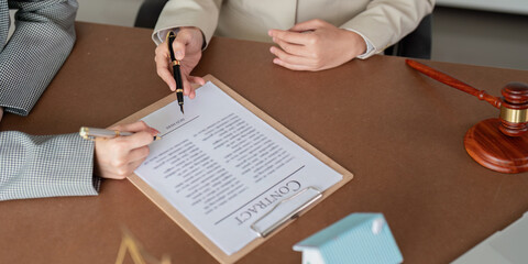Close-up of hands signing real estate contract document