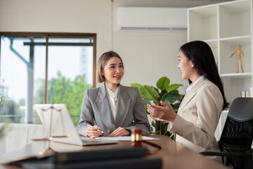 Fototapeta premium Two Asian businesswomen negotiating real estate deals in office