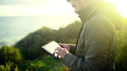 Nature, mountain and man with tablet online for adventure, holiday and vacation for hiking outdoors. Sunrise, morning and person on digital tech for social media, travel blog and memory for internet