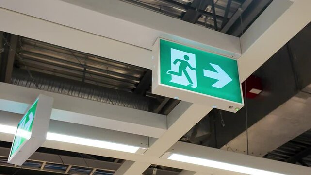 A green this way sign on the wall of the building 