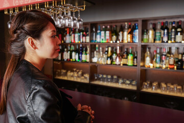 バーカウンターに座る大人の女性