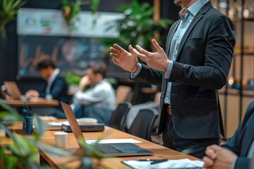 A man in a suit is giving a presentation in front of a group of people