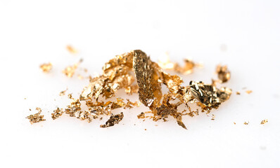 Scrapes of gold , dispersed on white paper background