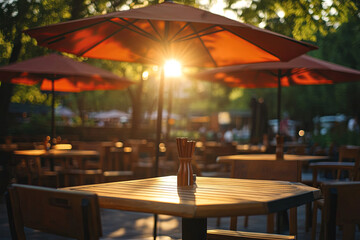 Fototapeta premium Cafe umbrellas, tables, and chairs bathed in sunlight