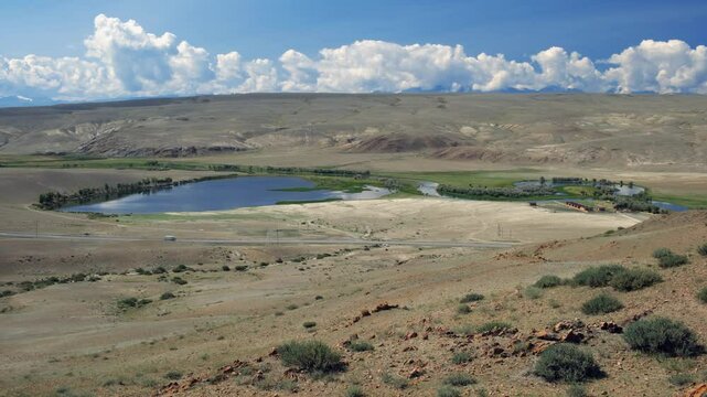 Video of natural steppe mountain landscape in Kosh-Agach Chuya intermountain basin. Jy foreground are river Chuya, small likes, Chuya Highway and touristic base.