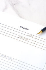 新規事業の立ち上げに先立ち、事業計画書を作成する起業家のイメージ