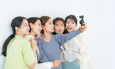 アクションカメラで自撮りするカジュアルな女性グループ