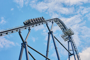 Roller coaster attraction in amusement park. Entertainment at summer holiday