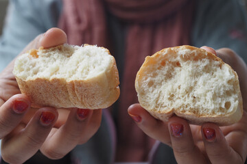 Hands are busy breaking fresh bread with wholesome ingredients beautifully arranged on a table