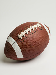 Brown American football with white laces on a white background