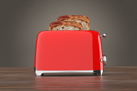 Red toaster is toasting two slices of bread on a wooden surface