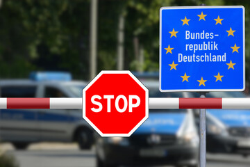 Stop sign, police cars and checks at the border with Germany