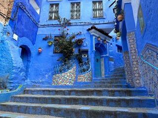 Chefchaouen, Morocco: Blue narow stairs with colourful walls and flowerpots into old walled city, or medina, North Africa travel destination