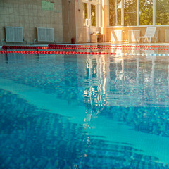 An indoor swimming pool awaits swimmers for training or leisure. the clear blue water and lane markers indicate a facility designed for both competitive and recreational swimming.