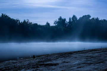fishing rods near the river against the background of the river at night, in the light of the moon the background is blurred