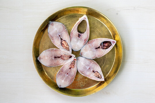 Slices of fresh raw hilsa fish on brass plate, ready for cooking. The famous ilish fish of the Padma River in Bangladesh.