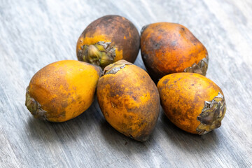 Fresh ripe betel nut (Areca catechu) on wooden background.