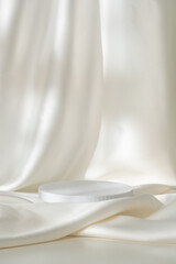 Modern Minimalist White Sculpture Displayed on Soft Draped Fabric in Natural Light