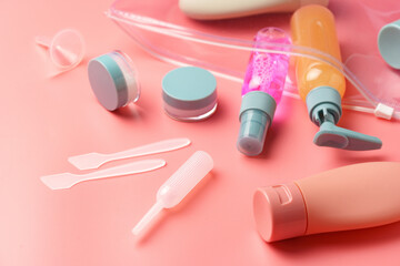 Clear Plastic Bag Containing Travel-Sized Toiletries on Pink Background