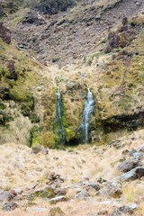 water flows over the mossy overgrown mountain rocks, The soda springs falls in New zealand