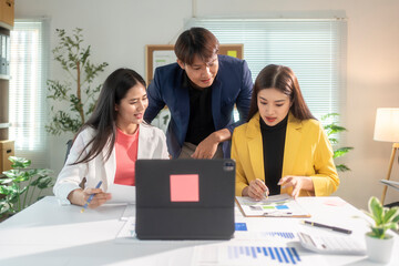 Obraz premium Asian business team working and brainstorming with data on a table in office meeting room