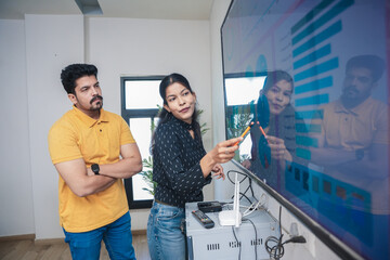 Young indian woman explaining company growth strategy through presentation to colleague in office. analysis, statistics charts and graph concept.Young indian woman explaining company growth strategy t