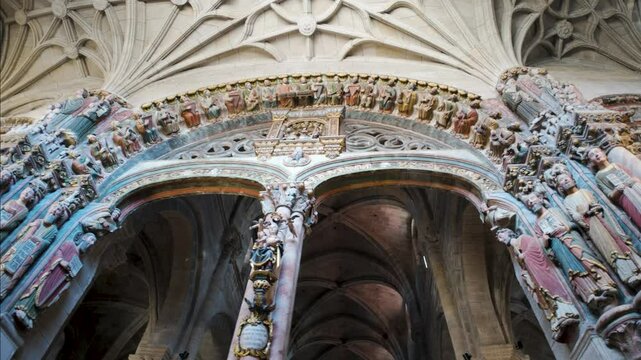 Trucking pan dolly upwards with carved apostle sacred figurines at top in stone, Cathedral of San Martin de Ourense, Galicia Spain