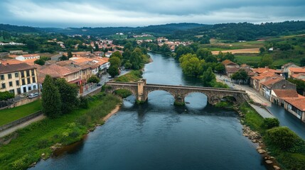 Obraz premium Top view of the ancient Roman bridge crossing the River in Chaves, with historic buildings and greenery