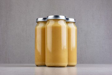 jars with apple or pear puree for baby food on a gray background
