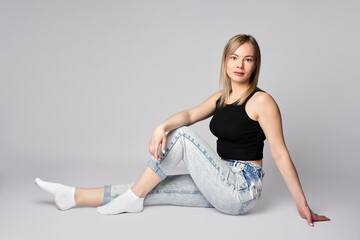 Fototapeta premium Portrait of a young woman on white background. Beautiful blonde woman wearing casual clothing, smiling and looking at camera