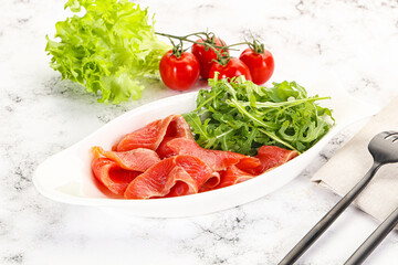 Sliced salmon with fresh arugula