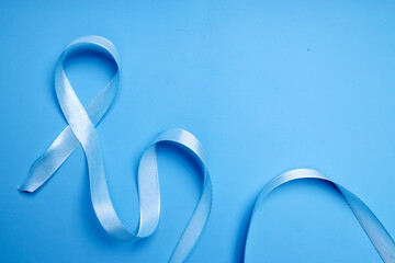 Blue ribbon on blue background for world diabetes day or prostate cancer awareness month