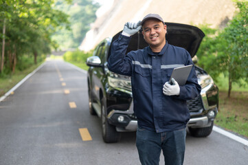 Asian male professional auto mechanic doing onsite service checking broken engine. Inspect the damage according to the list to replace parts and maintain the car on-site. emergency assistance service