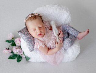 Baby Girl Sleeps On Tiny Chair In Newborn Studio Photo
