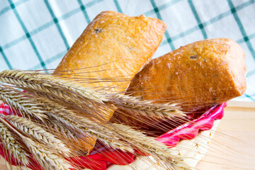 Ciabatta and wheat ears on the wooden table