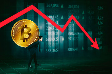 A businessman struggles under the weight of a large Bitcoin symbol with a downward trend in...