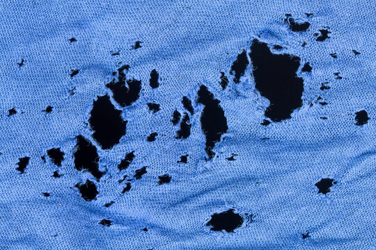 blue clothing material background damaged and holed