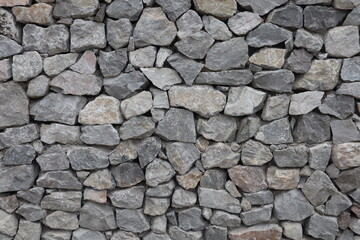 Wall constructed from rough, uneven stones in various shades of gray