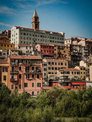 Charming Coastal Town Of Ventimiglia In Southern Europe With Colorful Houses, Lush Greenery, Vibrant Flowers, Serene River, And Clear Blue Sky Under The Warm Sun In Italy's Picturesque Land