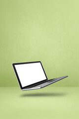 Floating computer laptop isolated on green. Vertical background