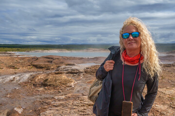 Woman standing in geothermal landscape, Haukadalur, Iceland