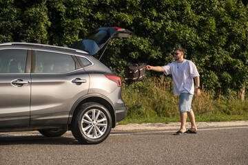 Man with Backpack at Open Car Trunk